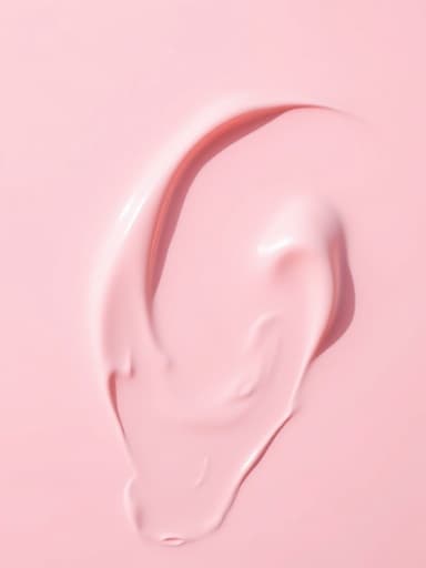 부드러운 핑크 톤의 크림 질감 BB크림이 부드럽게 초점이 흐려진 파스텔 톤의 추상적 색채 배경에 놓여 있어 고요하고 예술적인 분위기를 연출합니다.