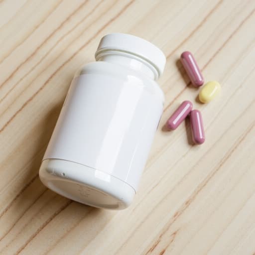 깨끗한 나무 테이블 위에 다양한 색상의 건강 보조제 알약이 담긴 투명한 유리병이 놓여 있습니다. 병 옆에는 하나의 알약이 테이블 위에 놓여 있으며, 자연광이 부드럽게 비추어져 차분하고 건강한 분위기를 만들어냅니다.