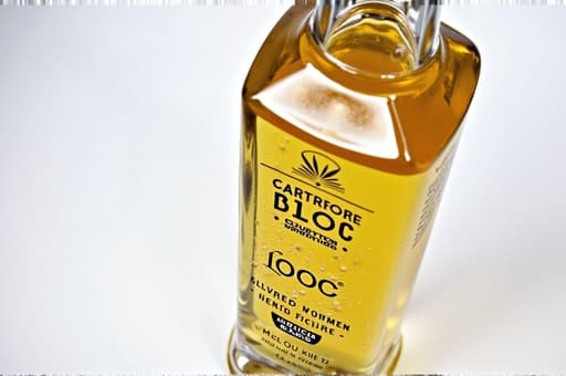 맑은 유리병에 생동감 넘치는 색상의 액체가 우아하게 담겨 있으며, 부드러운 그라데이션 배경 앞에 놓여 있습니다. 이 액체는 상쾌한 음료나 에센셜 오일일 가능성이 있으며, 빛을 받아 반짝이는 질감을 가지고 있습니다. 전체적인 분위기는 차분하고 초대하는 느낌을 주어 제품의 신선한 매력을 부각시킵니다.