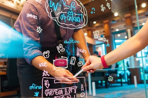 깔끔하고 현대적인 사무실 벽에 부착된 세련된 파란색과 흰색 보드가 있습니다. 보드는 부드럽고 지울 수 있는 표면을 가지고 있으며, 생동감 있는 파란색 가장자리와 흰색 중앙이 특징입니다. 보드 위에는 다양한 색상의 마커와 메모가 놓여 있습니다. 자연광이 가득한 공간은 브레인스토밍과 협업을 위한 영감을 주는 분위기를 자아냅니다.