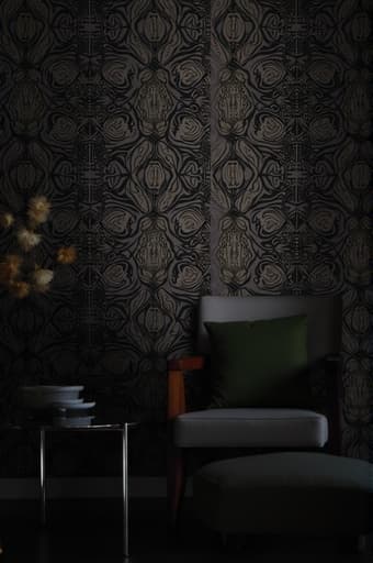 복잡한 기하학적 패턴의 흑백 벽지가 장식된 아름답게 디자인된 거실. 자연광이 공간에 쏟아져 들어와 벽지의 우아함을 강조하며 현대적인 가구와 잘 어울린다. 전체적인 분위기는 세련되고 차분하여 현대적인 집에 적합하다.