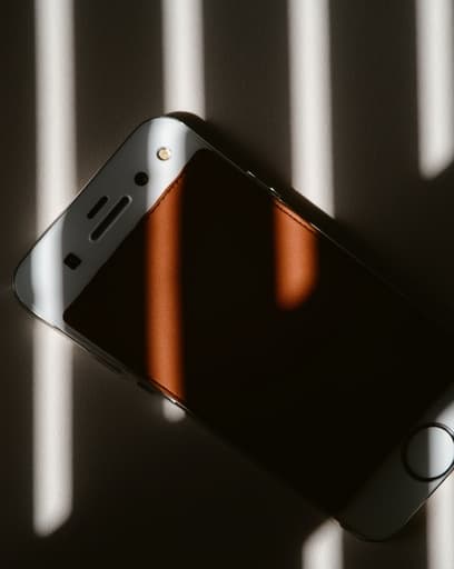 부드러운 그라데이션 배경 위에 세련된 셀폰의 클로즈업 뷰로, 매끄러운 본체와 생생한 화면이 드러나며, 섬세하게 드리워진 그림자가 그 디자인을 강조합니다.