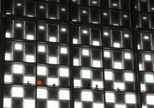 다양한 색상의 아트 패널로 장식된 큰 벽이 있는 현대적인 거실의 모습. 패널은 현대적인 터치를 더하며, 방은 잘 조명되어 있으며, 세련된 가구가 아트워크와 잘 어울려 초대하고 스타일리시한 분위기를 만듭니다.