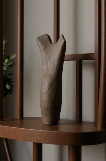 견고한 오크로 제작된 아름답게 디자인된 나무 의자가 있습니다. 이 의자는 인체공학적인 디자인과 자연스러운 나무 마감이 특징입니다. 의자는 아늑한 거실에 배치되어 있으며, 부드러운 조명과 따뜻한 색조로 둘러싸여 있습니다. 작은 테이블 위에 있는 식물이 초대하는 분위기를 더하고, 근처 창문을 통해 자연광이 들어와 장면의 따뜻함을 더욱 강조합니다.