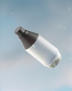 맑은 유리 물병이 전경에 뚜렷하게 자리 잡고 있으며, 표면에 하나의 응축된 물방울이 보입니다. 배경은 부드럽게 흐릿한 푸르른 녹지로, 햇빛이 부드럽게 장면을 비추며 상쾌하고 초대하는 분위기를 자아냅니다.