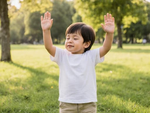 이미지는 편안한 티셔츠와 반바지를 입은 귀여운 3세 혼혈 아동의 반신을 담고 있으며, 졸린 표정으로 공원의 아침의 여유를 만끽하고 있습니다. 그는 두 손을 흔들며 친근하게 인사하고 있으며, 푸른 잔디와 나무가 있는 배경에서 따뜻한 아침 햇살이 비추고 있습니다.
