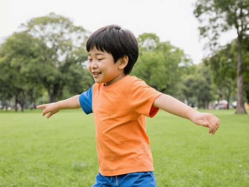 귀여운 외모를 가진 7세의 동양인 남성이 밝은 색상의 티셔츠와 반바지를 입고, 두 팔을 벌리며 춤추는 모습의 반신 사진. 졸린 듯 하지만 즐거운 표정을 짓고 있으며, 푸른 잔디와 나무들이 있는 공원이 배경입니다.