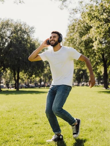 이 이미지는 20대 혼혈 남성이 트렌디한 티셔츠와 청바지를 입고, 화창한 공원에서 기쁘게 춤추고 있는 모습을 담고 있습니다. 자연스러운 외모와 매력적인 미소가 생동감 넘치는 분위기를 더하며, 배경의 푸릇푸릇한 풍경이 그 장면을 더욱 돋보이게 합니다.