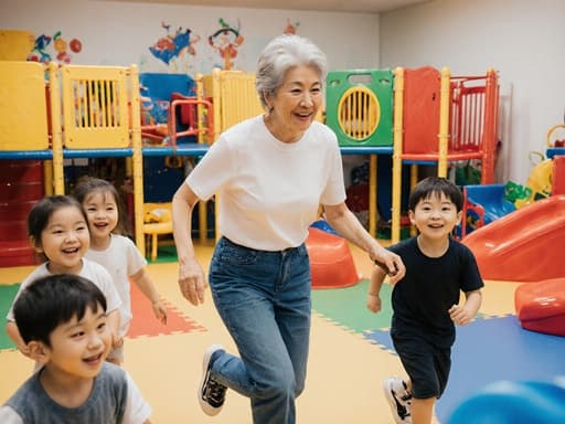 60대 한국인 여성의 반신 사진으로, 편안한 티셔츠와 운동화를 착용하고 아이들과 함께 놀기 위해 달리고 있는 모습입니다. 화사한 색상의 놀이 공간에는 다양한 장난감과 놀이기구가 배치되어 있으며, 가족의 즐거운 분위기를 만들어냅니다.