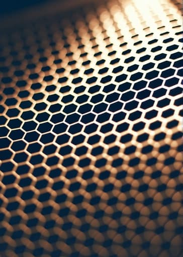 섬세하게 세밀한 벌집 패턴의 클로즈업 이미지로, 복잡한 육각형 모양과 풍부한 금빛 색조를 보여줍니다. 배경은 부드럽게 흐릿하게 처리되어 벌집의 자연스러운 아름다움을 강조하며, 따뜻하고 초대하는 분위기를 조성합니다.