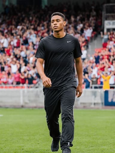 운동복을 입고 여유로운 표정을 지으며 걷고 있는 혼혈 남성의 전신 사진, 활기찬 스포츠 경기장 배경이 어우러져 활동적이고 자유로운 라이프스타일을 강조합니다.