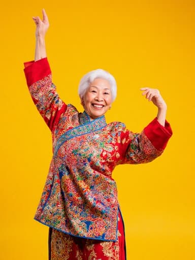 생기 넘치는 60대 아시아계 여성이 화려한 색상의 전통 의상을 입고 팔을 높이 들며 열정적으로 춤추는 모습의 전체적인 사진, 밝고 화사한 사진 스튜디오 배경.